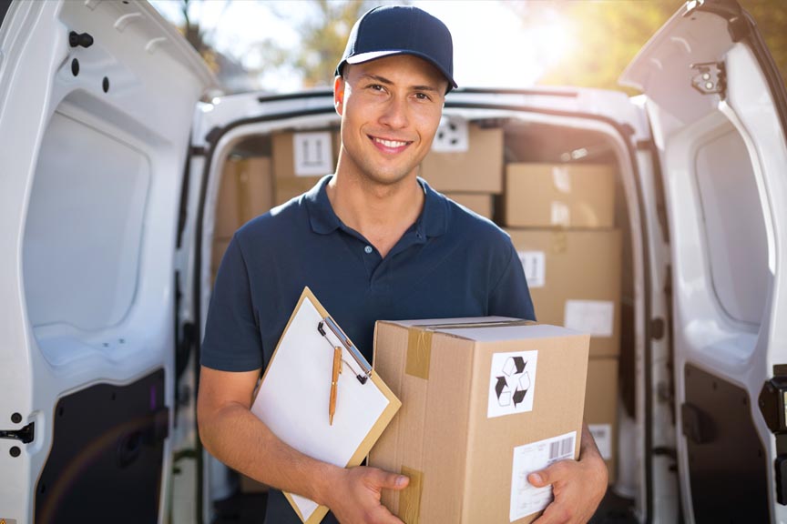 AA vending de;ivery driver holding a box and smiling while looking at the viewer